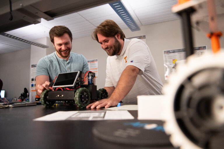 Graduate students Adam Foshie and Charles Rizzo work on autonomous vehicle GRANT (Ground Roaming Autonomous Neuromorphic Targeter) in a neuromorphic computing lab in the Min H. Kao Electrical Engineering and Computer Science Building