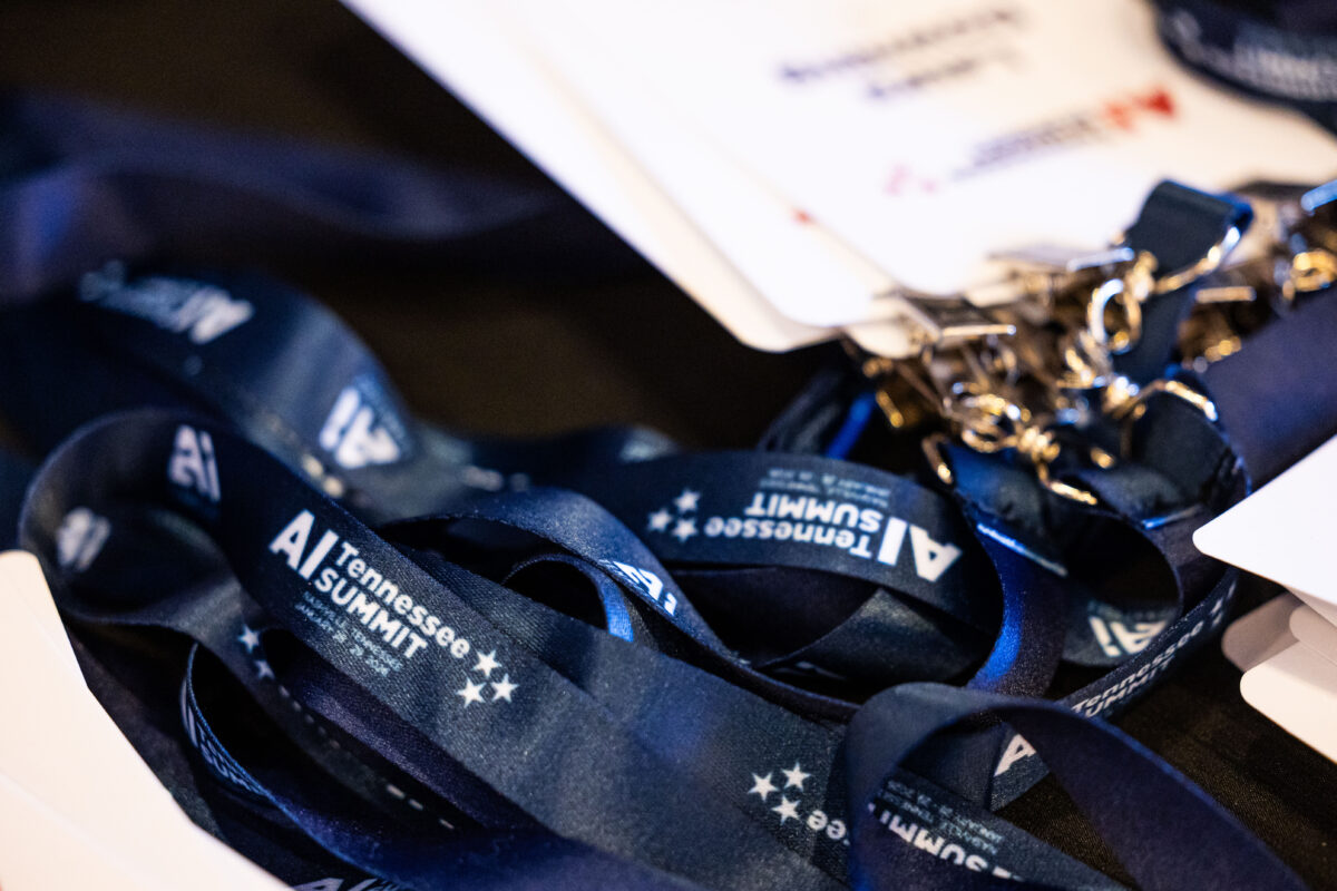 Lanyards and badges for the "AI Tennessee Summit" are prepared for attendees at the event.